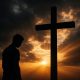 Conversion Therapy and the Gospel — silhouette of a man standing before a cross at sunrise, light breaking through stormy clouds.