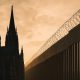 Catholic bishops immigration political message illustrated by a cathedral and border fencing