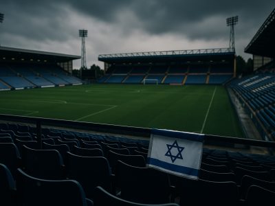 Jewish Discrimination in the UK shown by empty football stadium with Israeli flag draped over seat railing