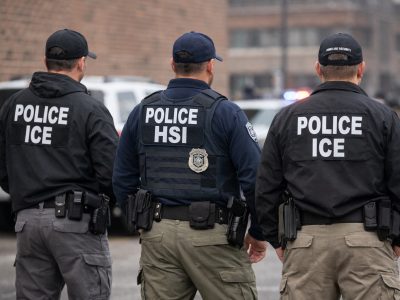 ICE agents standing calmly during a federal immigration enforcement operation